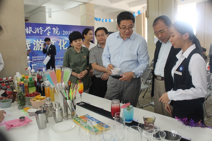旅游管理專業(yè)學生向王安興校長介紹作品（旅游學院供圖）.jpg